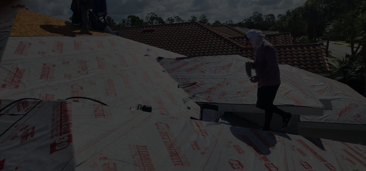 Contractor installing roofing underlayment during construction